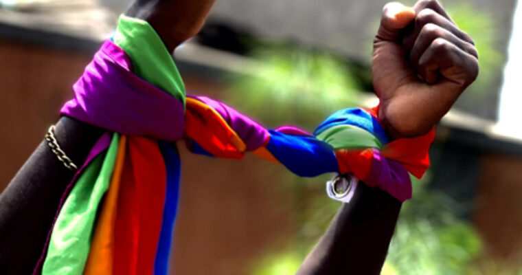 Header Queer Emergency Aid Alliance Uganda - hands with a rainbow flag